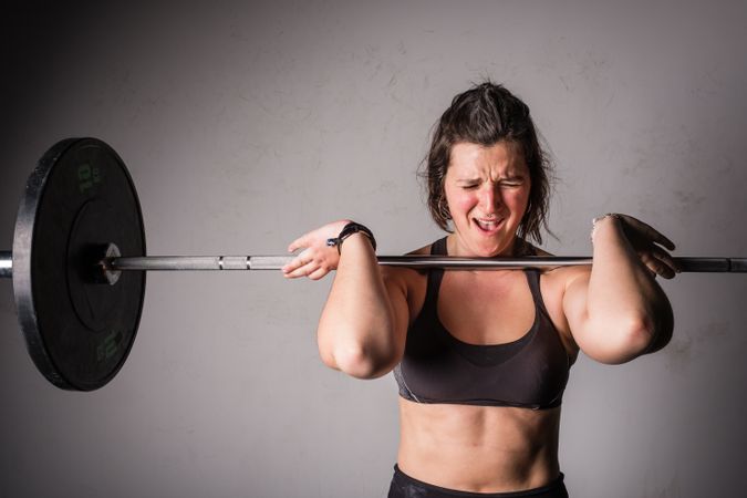 Woman lifting barbell in gym