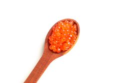 Spoon with red caviar isolated on blank background, top view