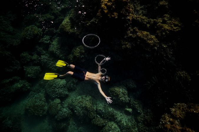 Man in snorkeling mask blowing bubbles underwater