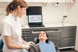 Happy stomatologist speaking with patient before treatment in dental clinic