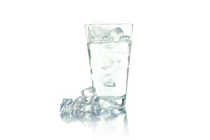 Tall glass full of ice water, with ice on  on blank background