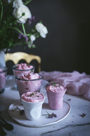 tasty glasses of strawberry mousse on a table with flowers
