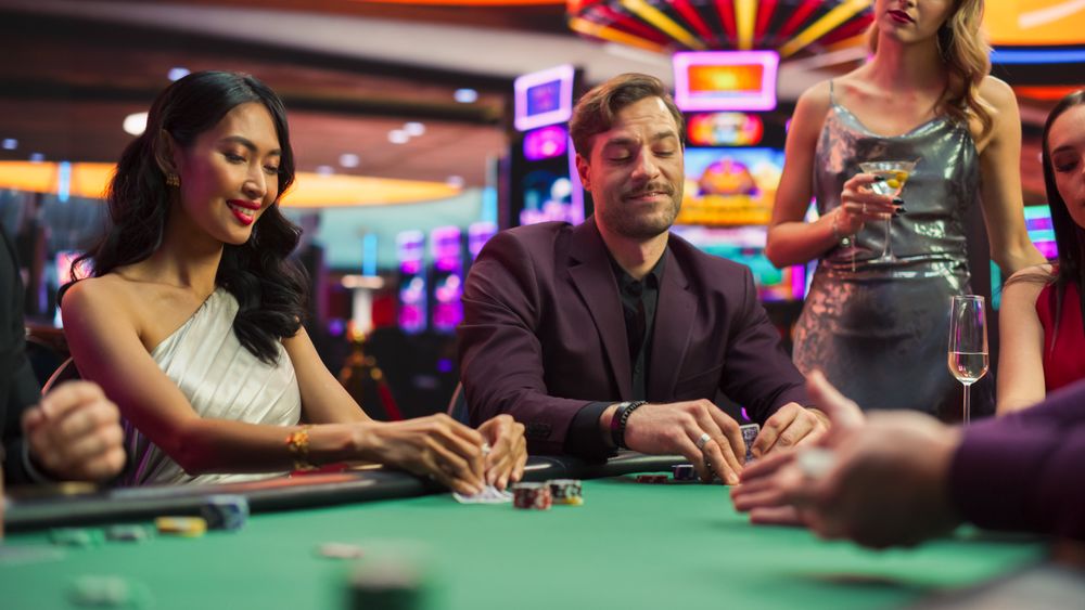 A Group of Diverse Gamblers Sitting at a Poker Table as the Croupier Deals the Playing Cards in a Fancy Casino.
