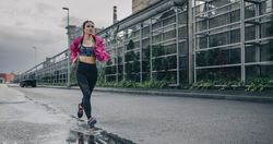 Sportswoman running in an industrial zone