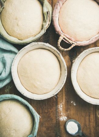 Top view of multiple baskets of bread dough