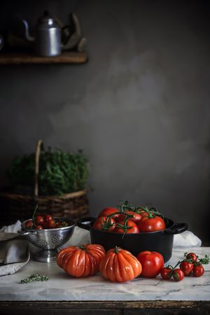 Ripe fresh tomatoes in pot on table