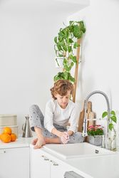 Boy washing hands with soap in modern kitchen