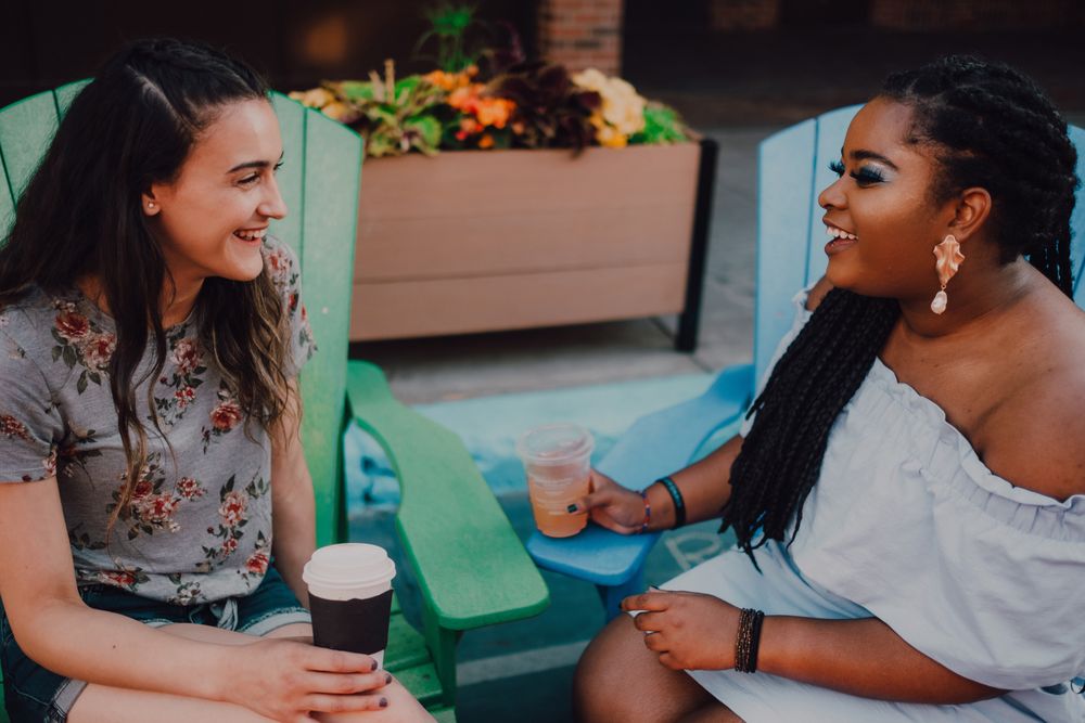 Multiethnic modern women talking at coffee shop