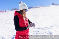 Woman in red snowsuit checking time on snowy mountain 4AzKzE