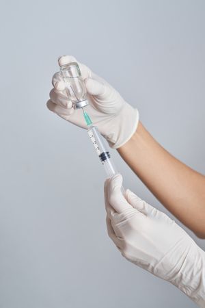 Anonymous medic drawing up medicine into syringe
