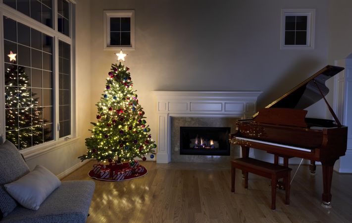 Bright Christmas tree in home with fireplace