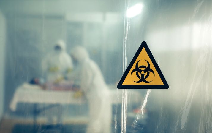 Doctors with bacteriological protection suits attending a patient