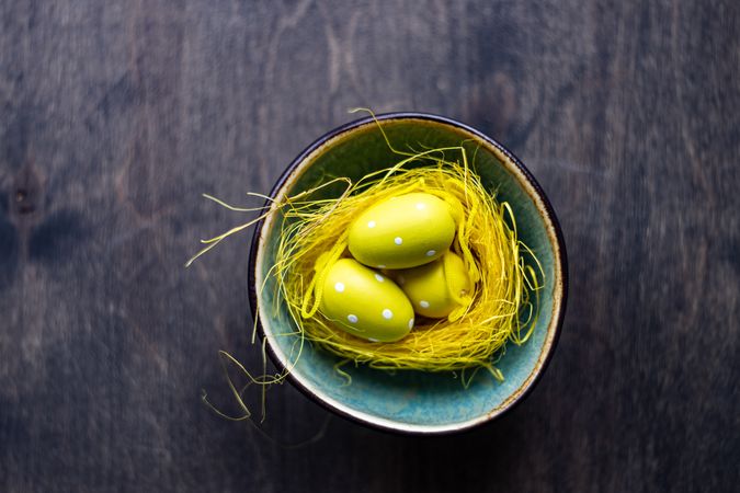 Bowl with decorative yellow nest and eggs