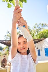 Cute girl playing on swing rope in yard
