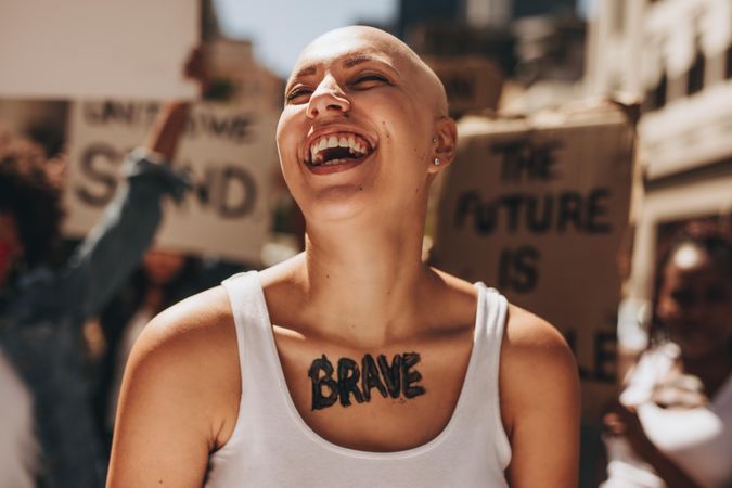 Bald woman laughing outdoors during a protest