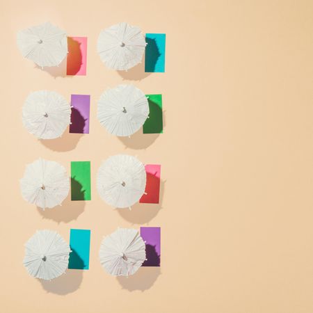 Aerial view of sun umbrellas and multicolored towels in rows on sand