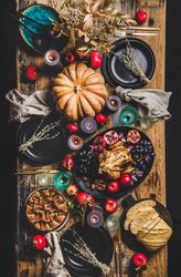 Thanksgiving table setting for gathering, with roast chicken, squash, pie, vertical composition