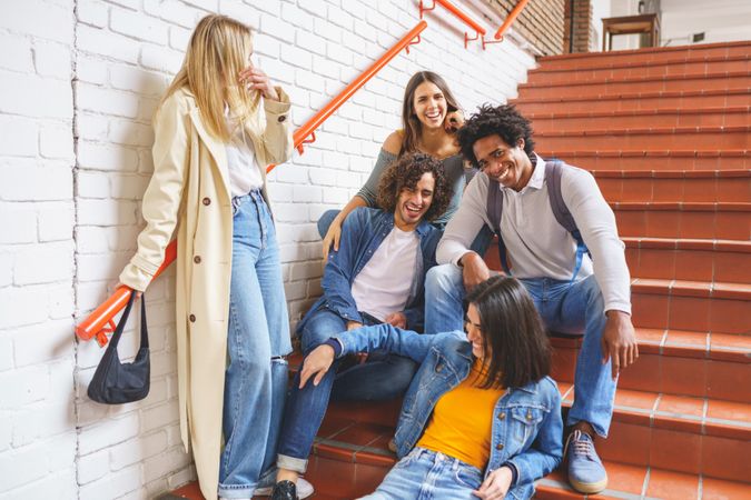 Smiling friends hanging out on brick steps