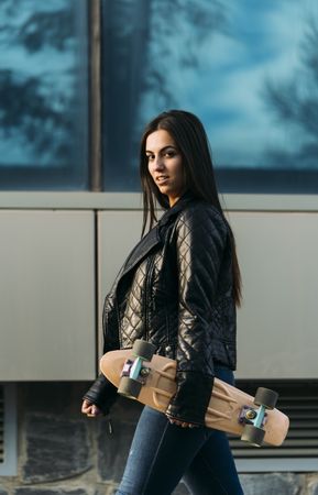 Young woman posing with skateboard