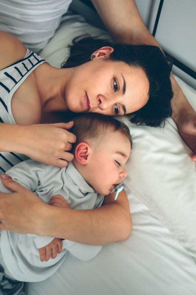 Man with wife watching his sleeping son
