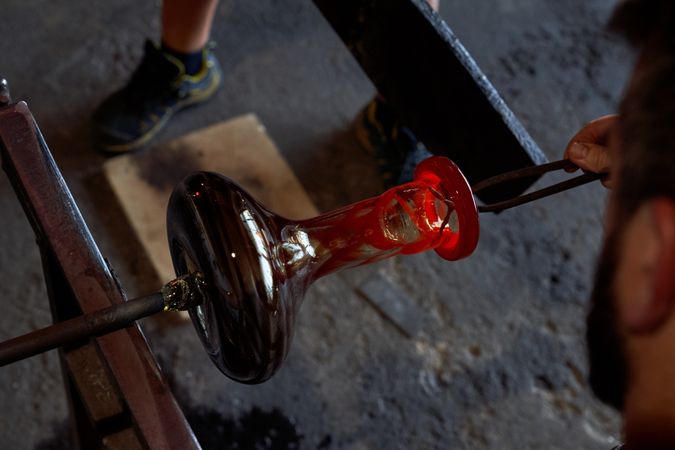 Anonymous male master making glass bottle