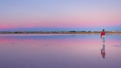 Woman admiring beautiful sky on empty beach