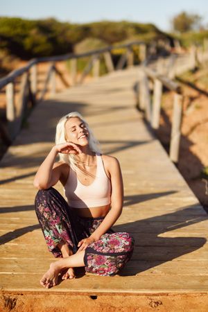 Woman sitting on wooden bridge