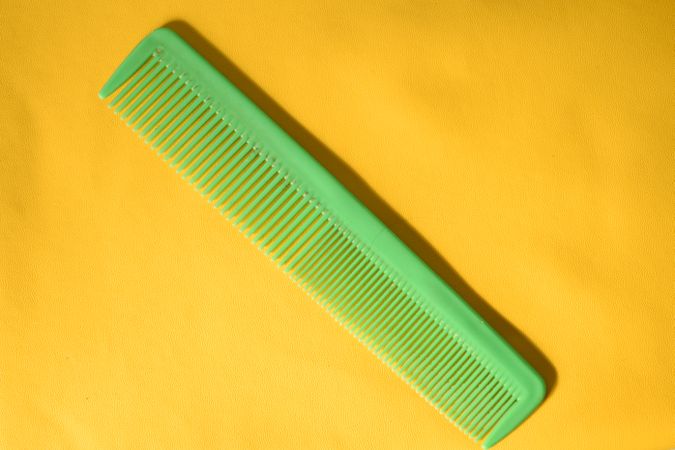 Green comb on yellow background