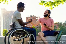 Joyful handshake between friends with disabilities outdoors 4mWdgo