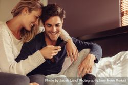 Loving man and woman smiling with a cell phone belnK4