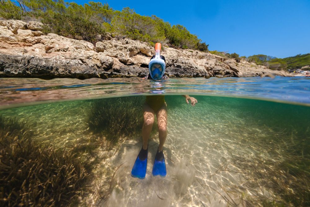 Anonymous person in snorkeling mask in ocean