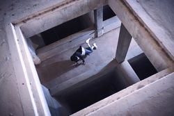 Young man performing breakdance element in unfinished building
