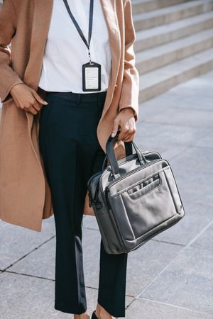 Cropped image of woman in pink coat holding a suitcase