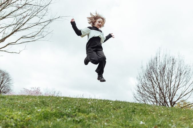 Cute girl jumping on hill