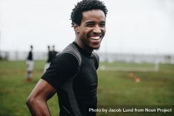 Portrait of a cheerful footballer standing on field during practice 5o1pmb