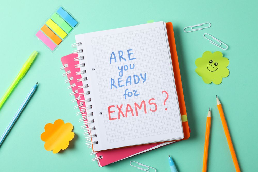 Top view of stationary and open notebook with the words “Are you ready for exams”