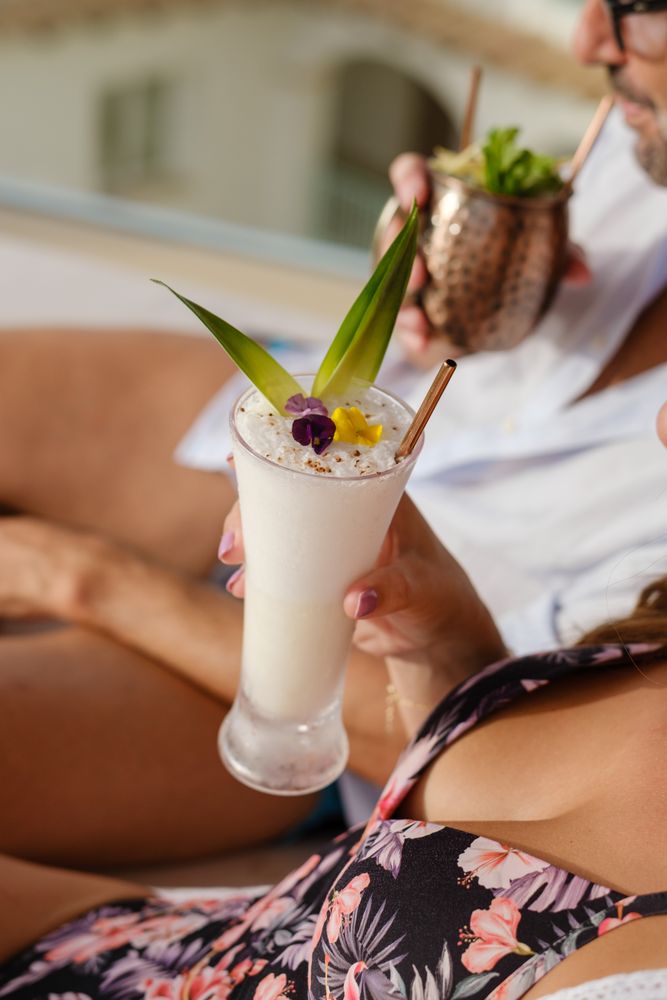Crop couple enjoying delicious cocktails together