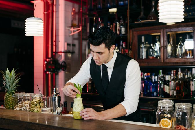 Barman working preparing drink in a glass