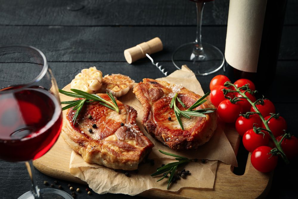 Composition with fried steaks and wine. Grilled food