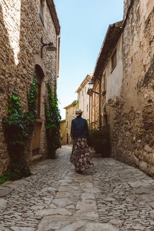 Woman walking in a narrow path in a village