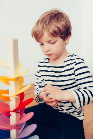 Boy playing with wooden construction pieces