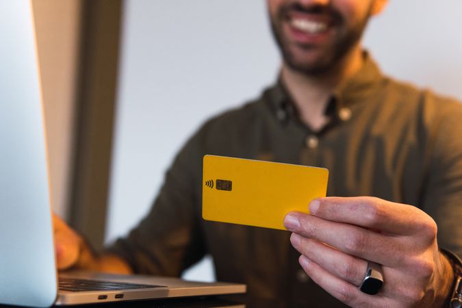 Anonymous man with credit card shopping online