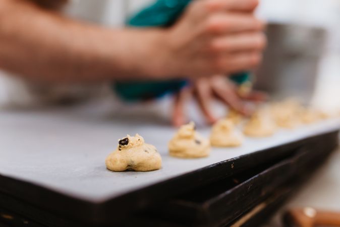 Crop baker squeezing dough on tray