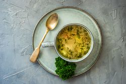 Top view of hearty chicken soup on plate