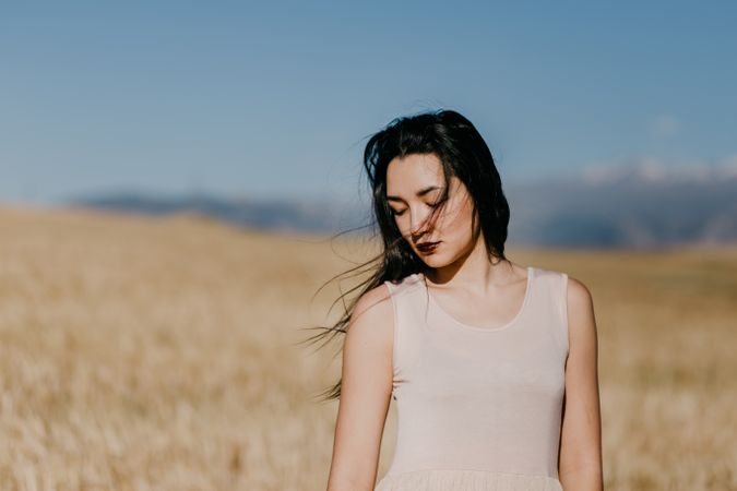 Woman standing in field looking down