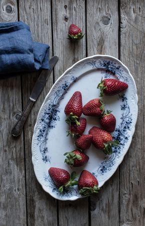 Plate with strawberries near napkin and knife