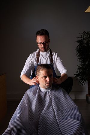 Barber making haircut to man