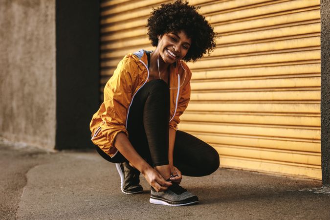 Fitness woman tightening her shoes during workout