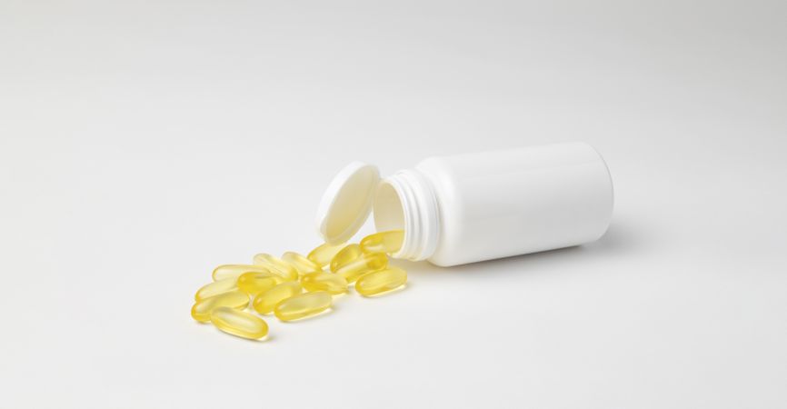 Mockup of a bottle of omega 3 capsules, food supplement, lying down with copyspace