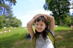 Happy girl standing in a grassy park